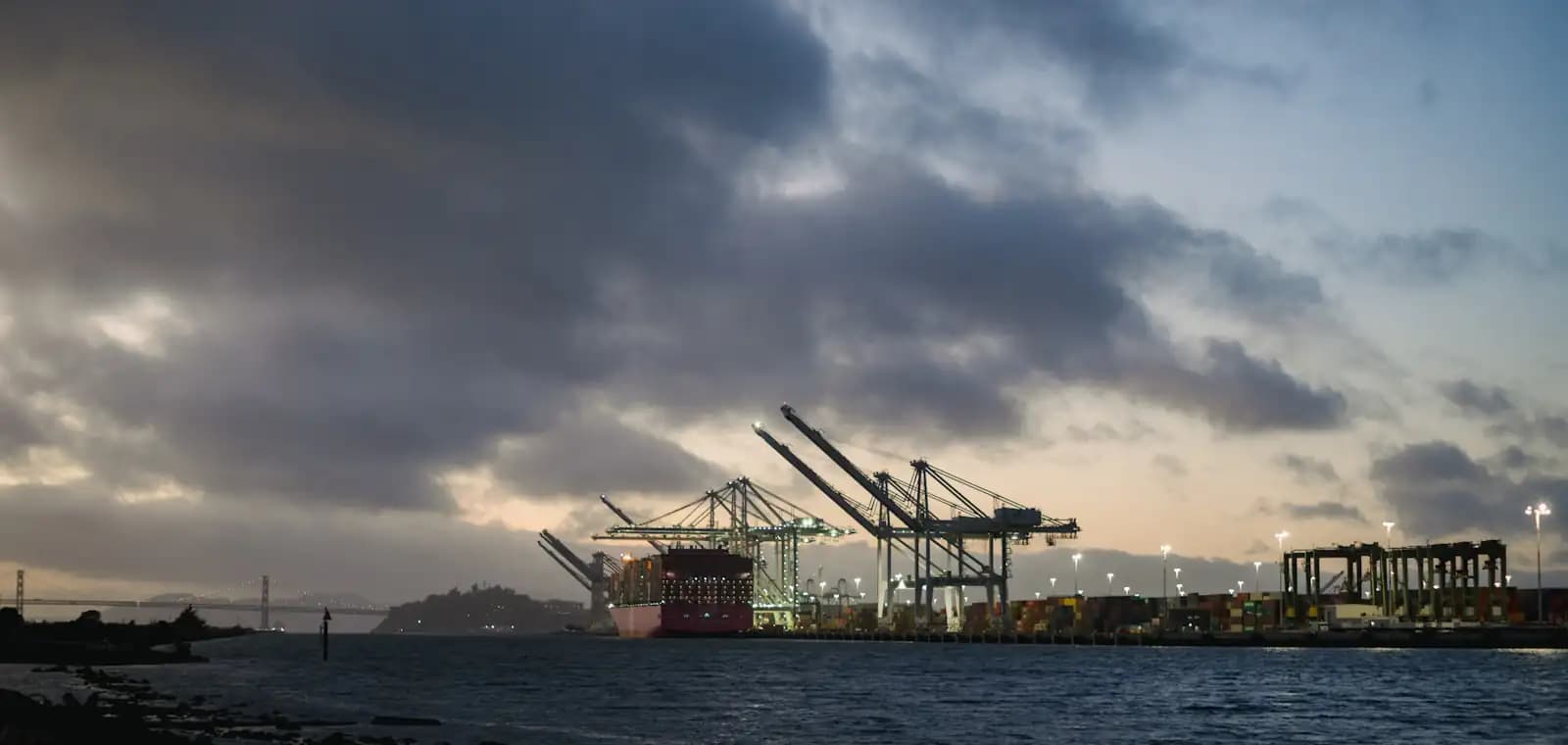 Gantry cranes working a container vessel at a deepwater port at dusk